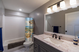 World Explorer shower curtain pulled open in a gray kids bathroom