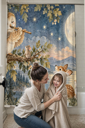 Mom drying her toddler in a hooded towel in front of the Owl Flute shower curtain