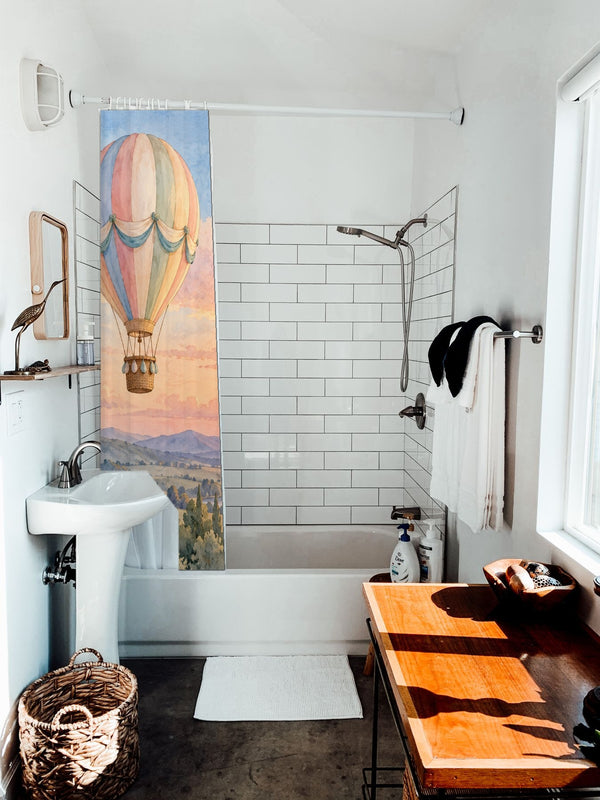Sunset Flight Hot Air Balloon shower curtain hanging on the rod over a white bathtub