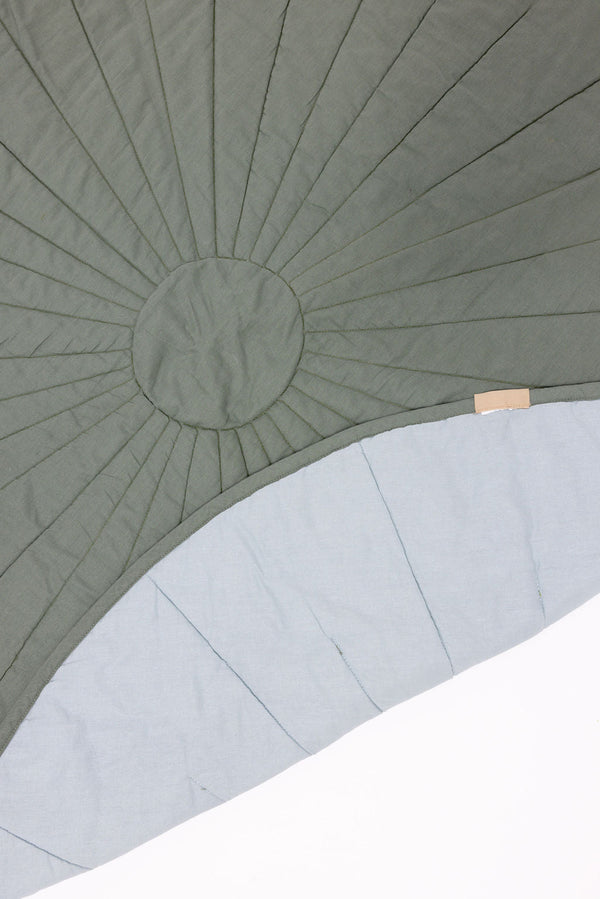 Linen quilted playmat in Acadian/Dove color, angled view showcasing soft texture and design for baby playtime.