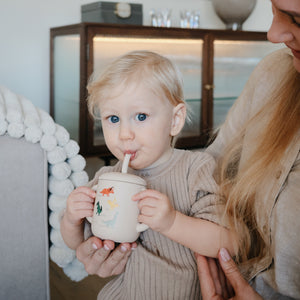 Silicone training cup with straw at a 37-degree angle, perfect for toddlers learning to drink independently.