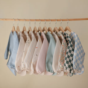 Long sleeve bib for babies, featuring a colorful design, angled view showcasing its protective coverage and comfort.