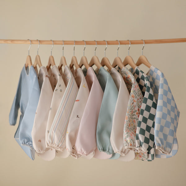 Long sleeve bib for babies, featuring a colorful design, angled view showcasing its protective coverage and comfort.