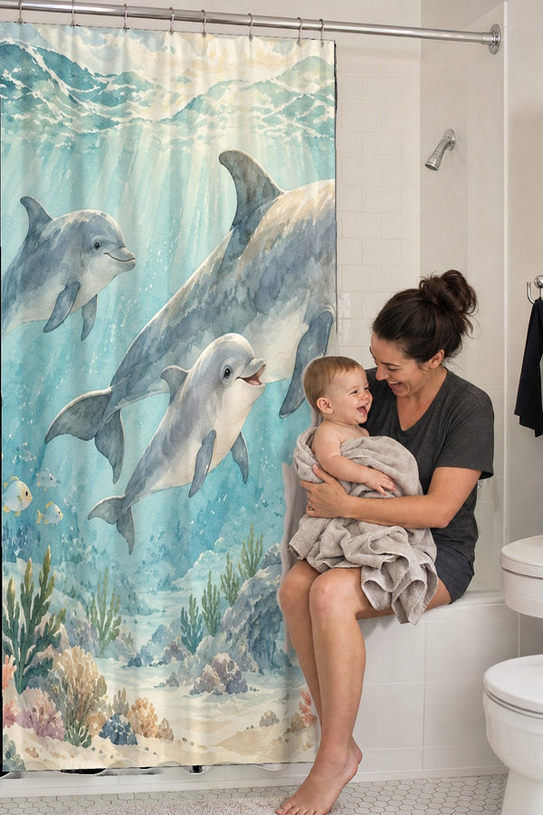 Mom holding her baby on the tub edge next to the Dolphin Family Ocean shower curtain