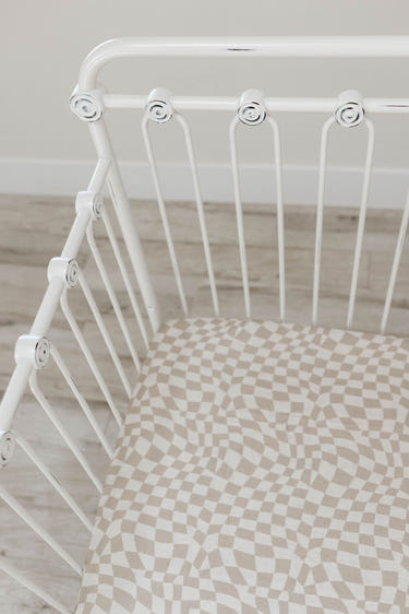 Muslin crib sheet in wavy checker pattern, perfect for stylish and comfortable nursery bedding.