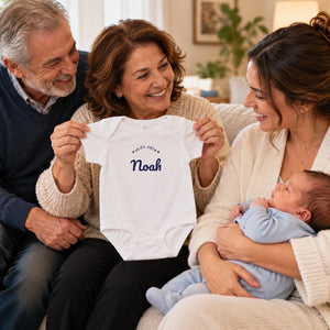 Grandparents showing the embroidered Noah bodysuit to their daughter and newborn grandson