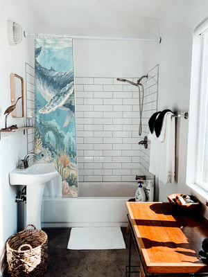 Ocean Kingdom shower curtain hanging on the rod over a white bathtub