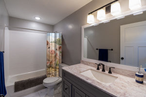 Piglet Family Farm shower curtain pulled open in a gray kids bathroom