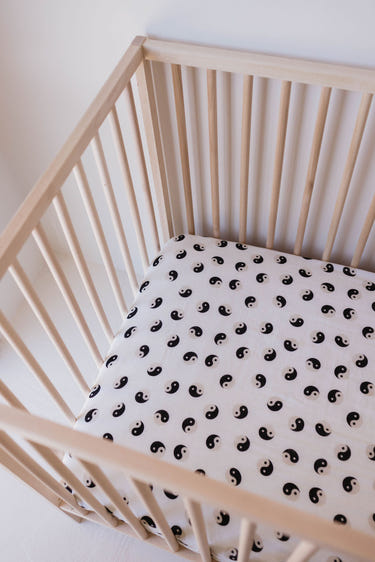 Muslin crib sheet in black and ivory yin yang design for stylish nursery bedding.