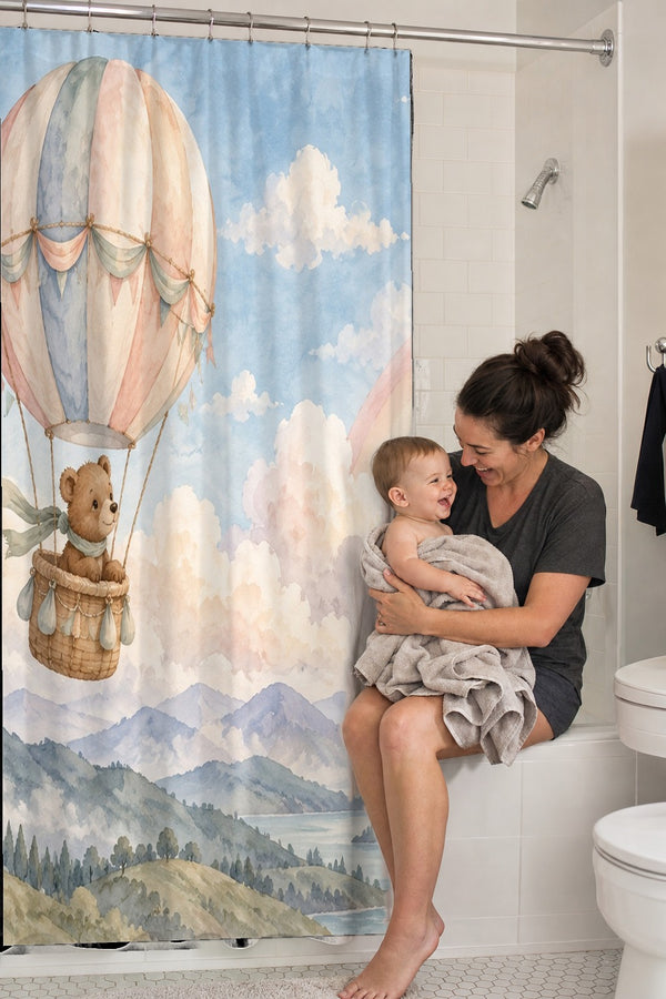 Mom holding her baby on the tub edge next to the Bear Hot Air Balloon shower curtain