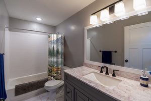 Canoe Lake Camping shower curtain pulled open in a gray kids bathroom
