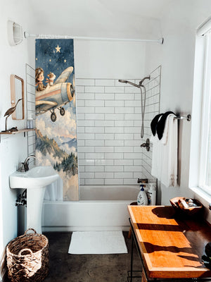 Moonlit Flight shower curtain hanging on the rod over a white bathtub