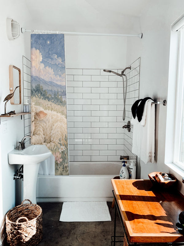 Meadow Lamb shower curtain hanging on the rod over a white bathtub
