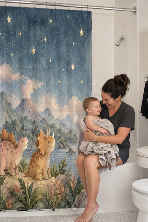 Mom holding her baby on the tub edge next to the Moonlit Dinosaurs shower curtain