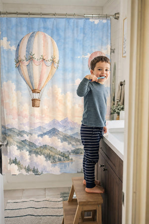 Child brushing teeth in a family bathroom with the Mountain Hot Air Balloons shower curtain