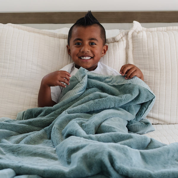 Cozy LUSH toddler blankets in soft colors, perfect for snuggling and warmth. Ideal for blankets and swaddles.