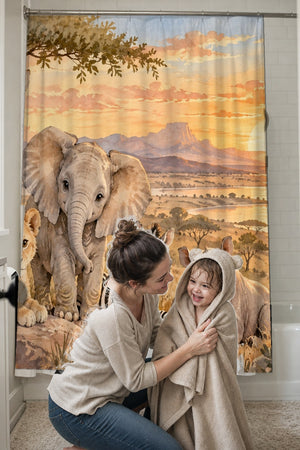 Mom drying her toddler in a hooded towel in front of the Sunset Savanna shower curtain