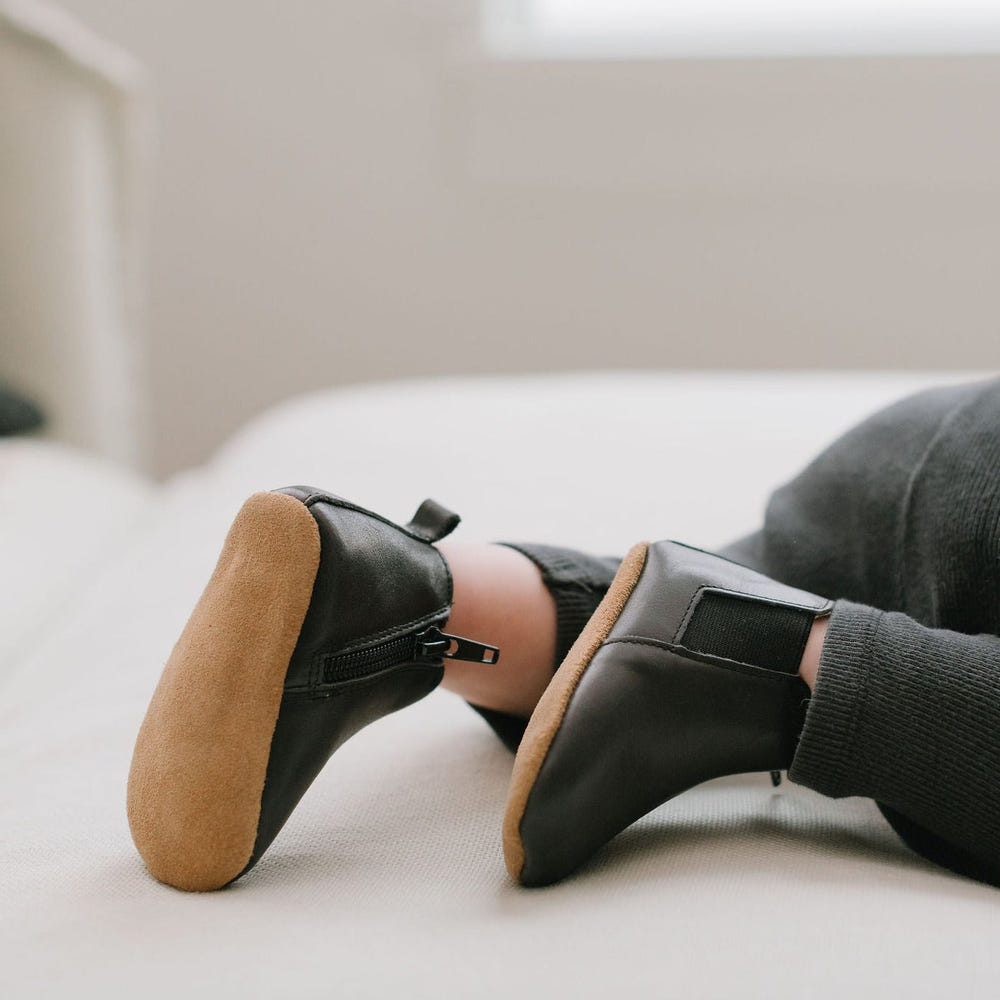 Black Chelsea Boot with soft sole for babies, perfect for stylish and comfortable footwear.
