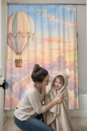 Mom drying her toddler in a hooded towel in front of the Sunrise Hot Air Balloon shower curtain