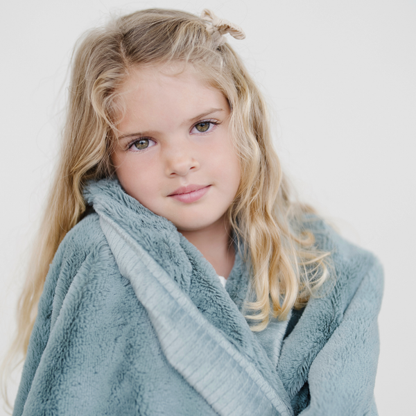 Lush toddler blankets in soft fabric, perfect for cozy naps and snuggles, displayed at a stylish angle.