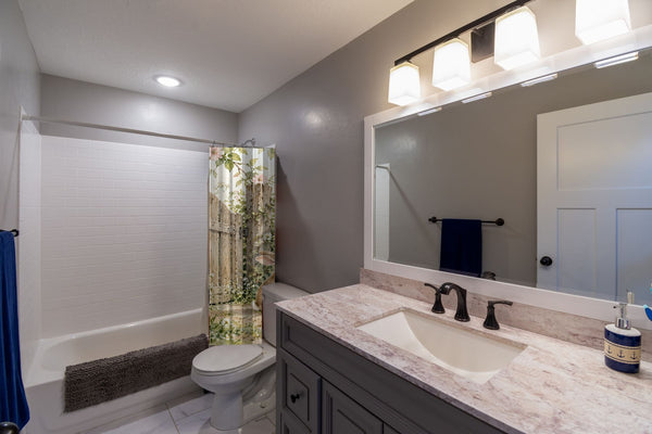 Butterfly Gate Bunny shower curtain pulled open in a gray kids bathroom