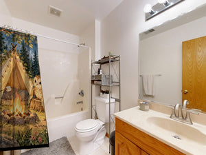 Moonlit Forest Camp Camping shower curtain on a tub shower combo in an American family bathroom