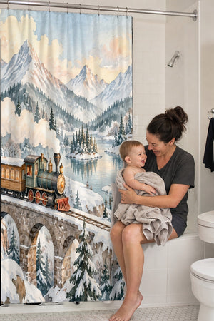 Mom holding her baby on the tub edge next to the Winter Train shower curtain