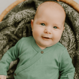 Basil Green long sleeve bodysuit for babies, angle view showcasing soft fabric and stylish design.