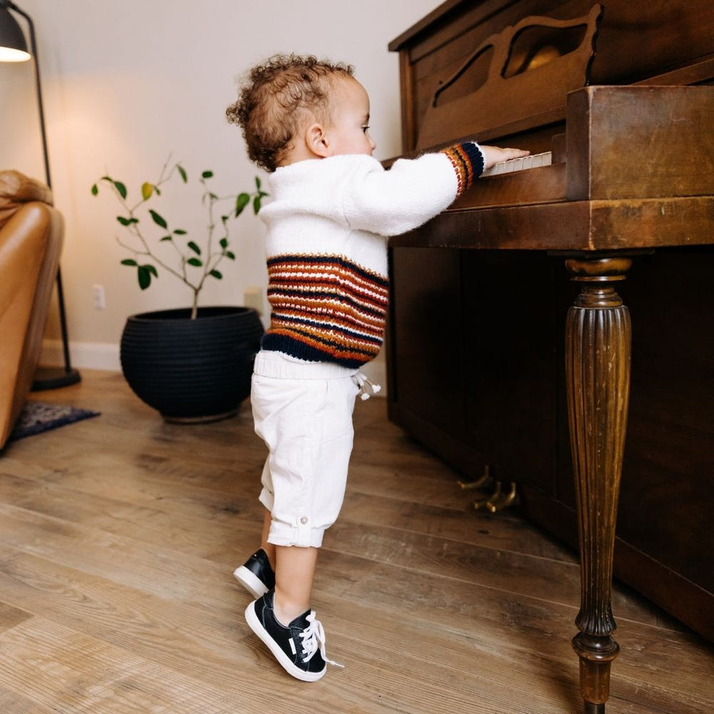 Black low top sneakers for babies, stylish and comfortable footwear for little ones.