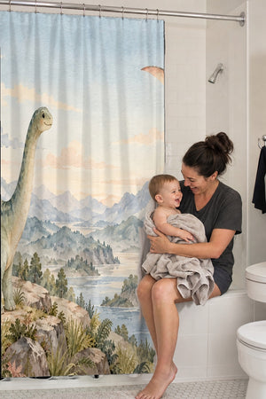 Mom holding her baby on the tub edge next to the Mountain Dinosaur shower curtain