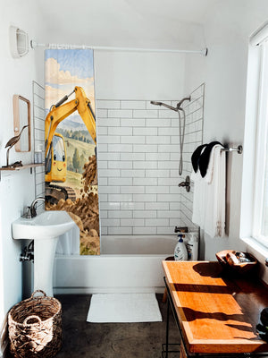 Sunrise Excavator shower curtain hanging on the rod over a white bathtub