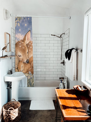 Woodland Friends shower curtain hanging on the rod over a white bathtub