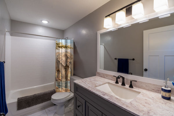 Elephant Family Safari shower curtain pulled open in a gray kids bathroom