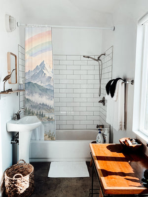 Sunrise Lake Rainbow shower curtain hanging on the rod over a white bathtub