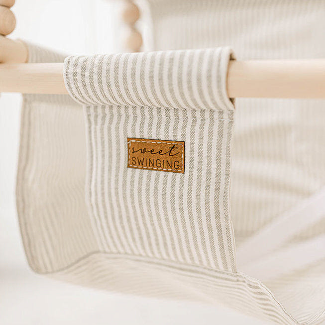 Greige and vanilla striped indoor baby swing, perfect for cozy playtime and relaxation.