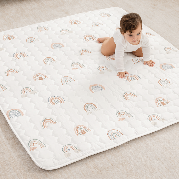 Rainbow play mat with non-slip bottom, angled view showcasing vibrant colors and safe play surface for babies.