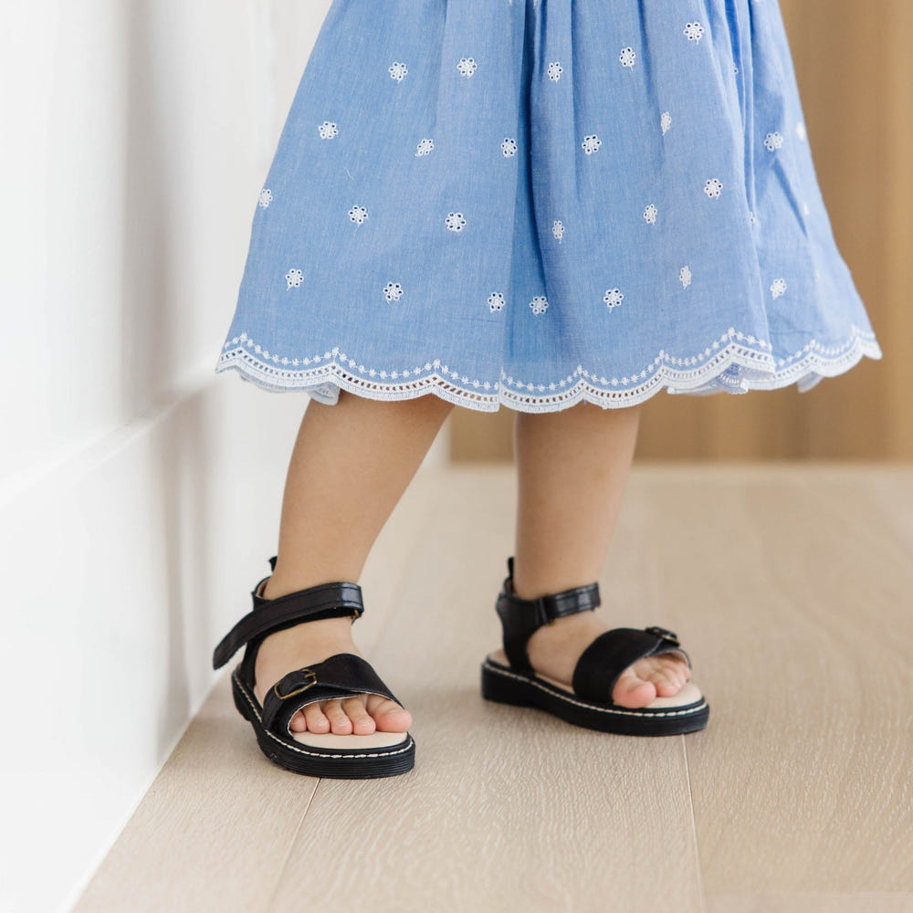 Black lug sole sandals for babies, featuring a stylish design and comfortable fit. Perfect for summer outings.
