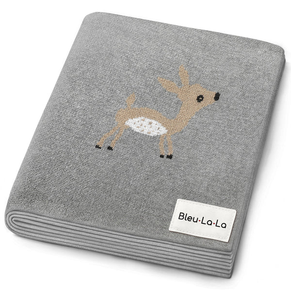 Luxury cotton deer knit swaddle baby blanket in soft colors, angled view showcasing its cozy texture and design.