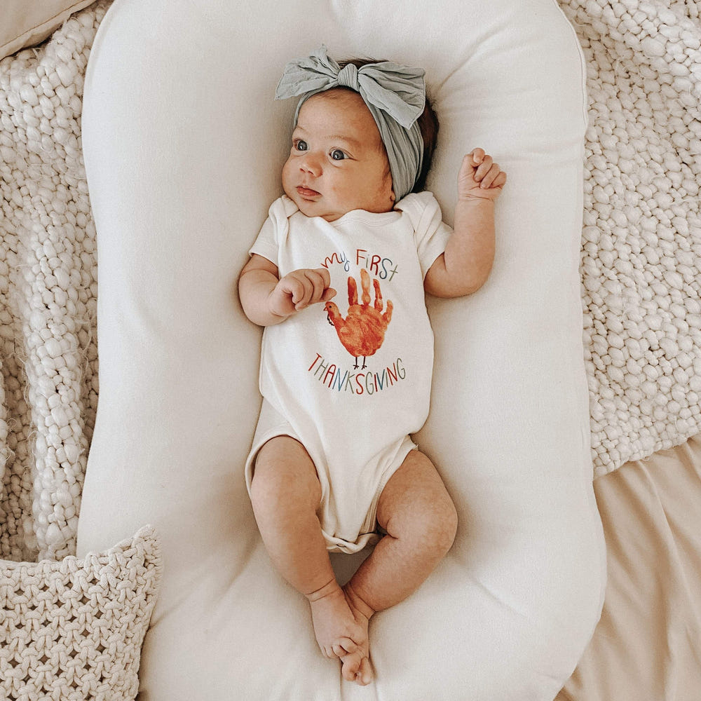 Thanksgiving-themed graphic bodysuit for babies with hand design, perfect for festive celebrations.