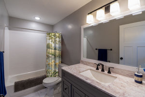 Ducklings Pond Farm shower curtain pulled open in a gray kids bathroom