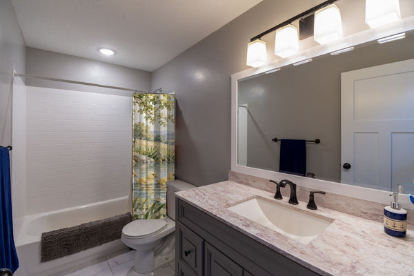 Ducklings Pond Farm shower curtain pulled open in a gray kids bathroom