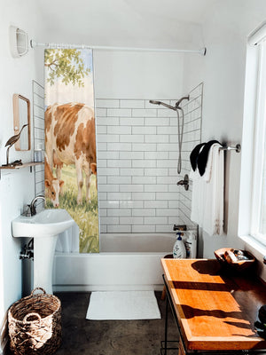 Cow and Calf Farm shower curtain hanging on the rod over a white bathtub