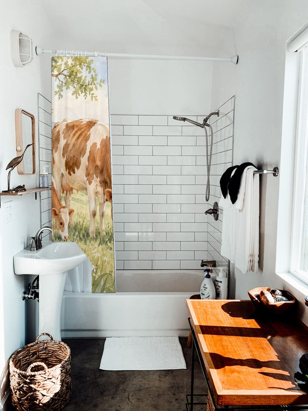 Cow and Calf Farm shower curtain hanging on the rod over a white bathtub