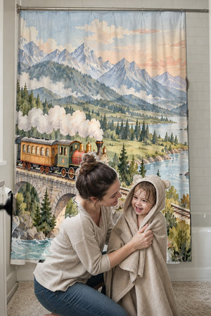 Mom drying her toddler in a hooded towel in front of the Panoramic Train Journey shower curtain