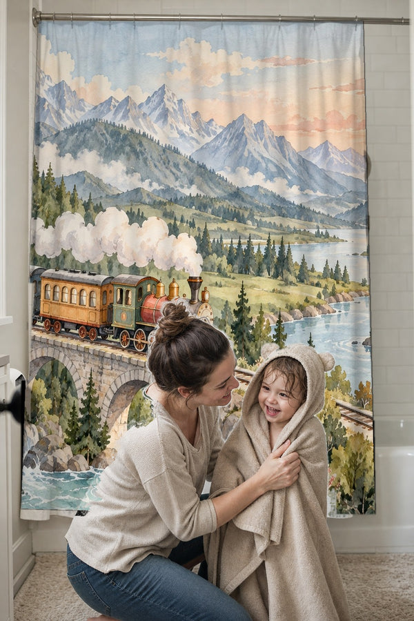 Mom drying her toddler in a hooded towel in front of the Panoramic Train Journey shower curtain