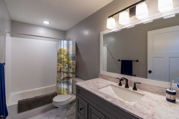 Countryside Train shower curtain pulled open in a gray kids bathroom