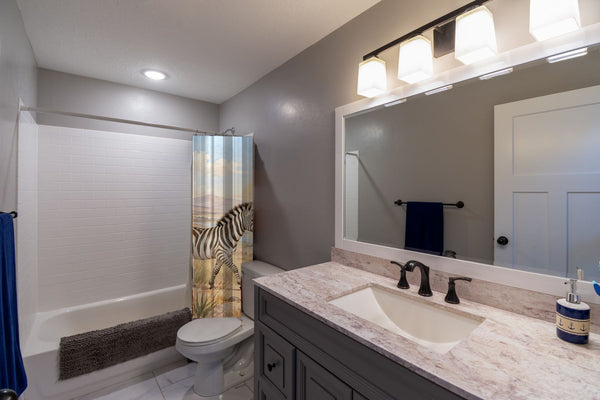 Zebra Family Safari shower curtain pulled open in a gray kids bathroom
