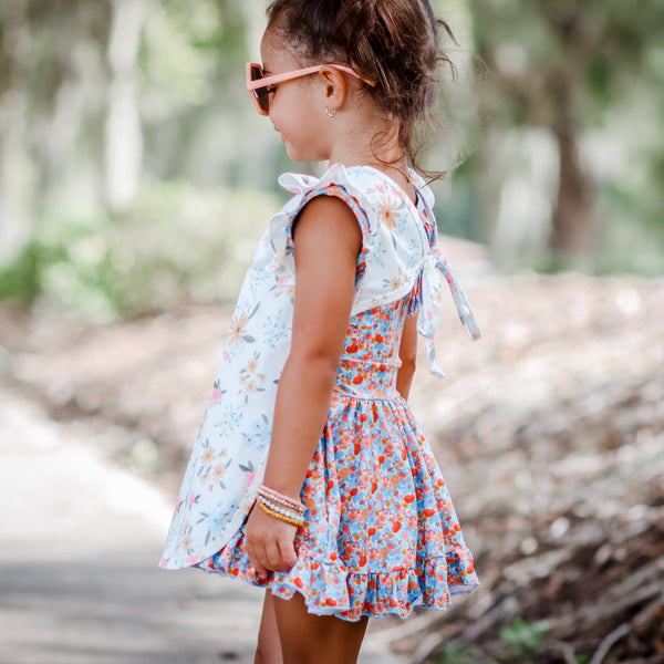 Pastel Floral Flutter Bapron for babies, angled view showcasing its vibrant design and practical features.