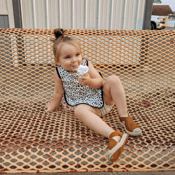 Organic Dot Bapron for babies, featuring a stylish design and comfortable fit, angled view showcasing its unique shape.