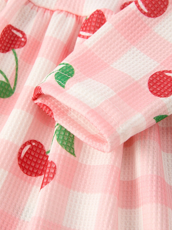 Waffle Cherry Girls Long Sleeve Dress in angle view, featuring a playful cherry print and cozy design for toddlers.